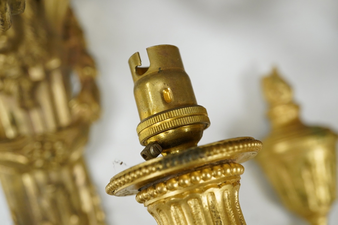 A pair of Adam style cast brass three branch wall sconces - 36cm high, with similar two branch sconce